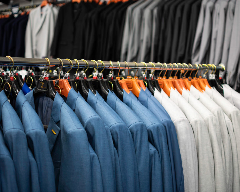 Tailored Mne's Suits displayed on rack, shades of blue, white, grey and black at Dolce Vesta. 
